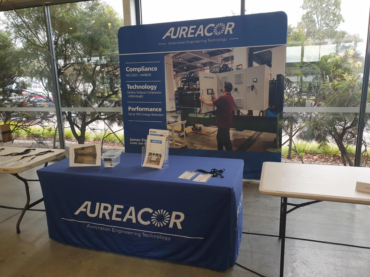 Aureacor trade-night display with a branded table, brochures and chiller photograph on the backdrop